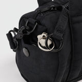 Black nylon duffle bag hardware detail with metal rings and strap clips