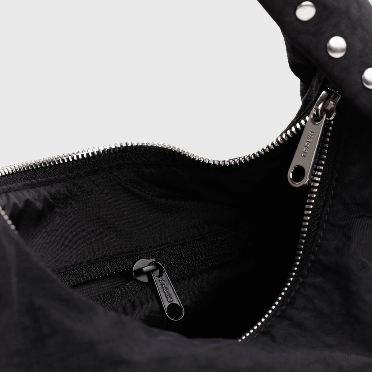 Black nylon bag interior with zipper and metal pull at top opening