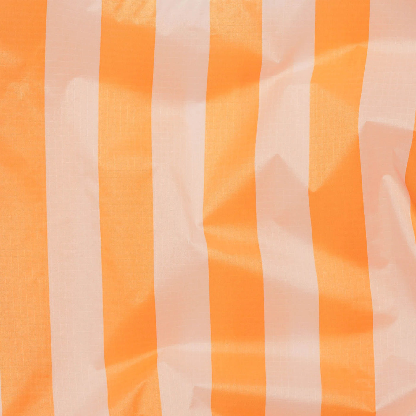 The Baggu Standard Reusable Bag - Tangerine Stripe features orange and white vertical tangerine stripes on the fabric, complemented by subtle wrinkles that add character.