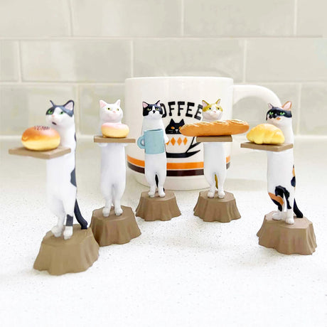 The Kitan Club Cat Bakery Waiter Blind Box includes five bakery cat figurines on stumps, each holding a mini tray with bread or a mug, and accompanied by a large coffee mug in the background.