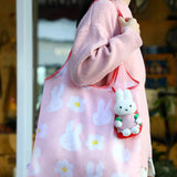 Pink plush bunny tote bag with floral print and small bunny keychain charm
