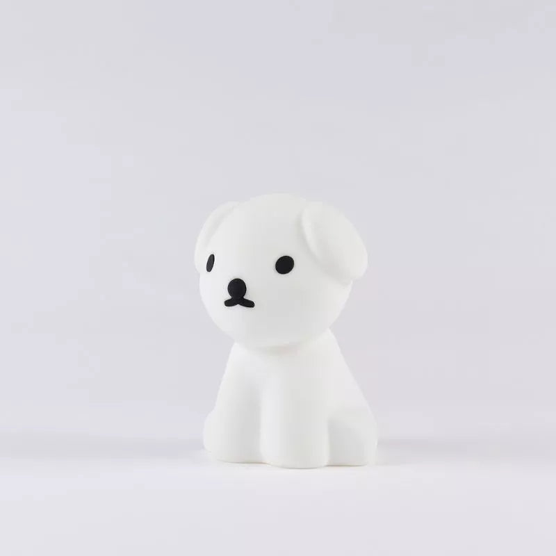 The Snuffy Dog Miffy Night Light, measuring 15cm, by the Miffy brand is a small, white dog figurine with cartoon-style design. Made from BPA-free silicone, it features black eyes and a nose that perfectly embodies the charming essence of Miffy and Friends against a plain background.