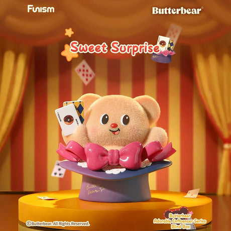 Plush bear popping from magician’s hat holding playing cards on stage with red and yellow striped curtains background