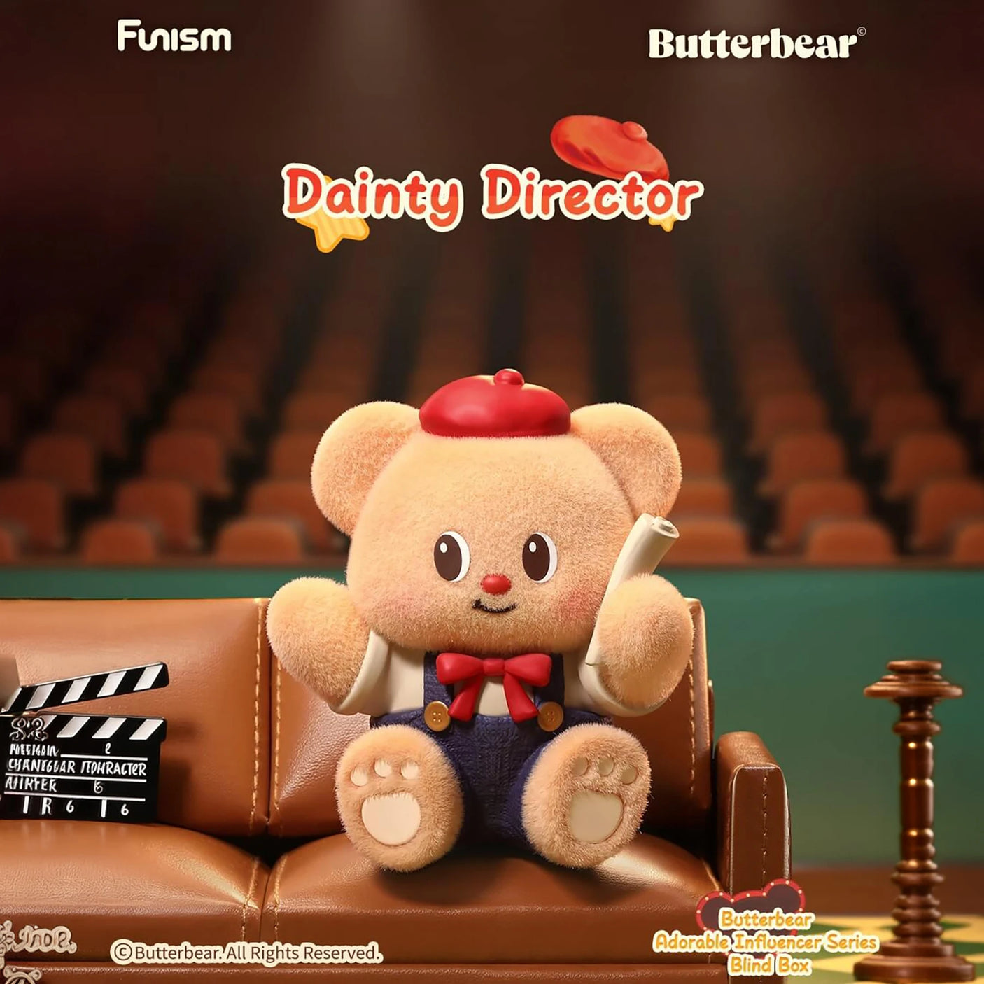 Plush bear wearing red beret and bow tie holding film script sitting on leather couch in theater setting