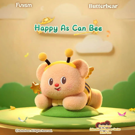Plush bear dressed as a bee with antennae and wings lying on green surface with soft background clouds and hills