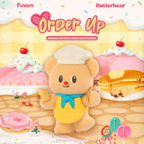 Fluffy bear toy in chef hat and yellow apron holding menu and spoon with candy and dessert-themed background