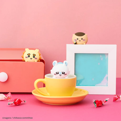 Three adorable Sonny Angel Chiikawa Hippers Blind Box figures are displayed with a yellow teacup, pink drawer, white frame, and candies on a pink background—perfect stick-on companions for fans and collectors.