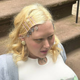 Cat charm bobby pins clipped in blonde hair, featuring pink barrette clips and charms