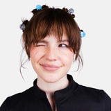 Woman wearing blue micro claw hair clips in a short hairstyle with bangs.