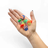 Micro claw hair clips held in hand, red, blue, green, and yellow mini clips