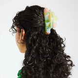 Sherbet jelly translucent claw clip securing curly black hair at the back