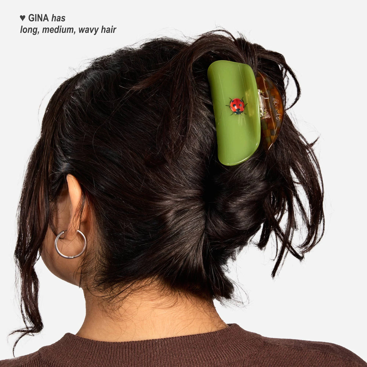 Green hair claw clip with red ladybug on dark wavy hair