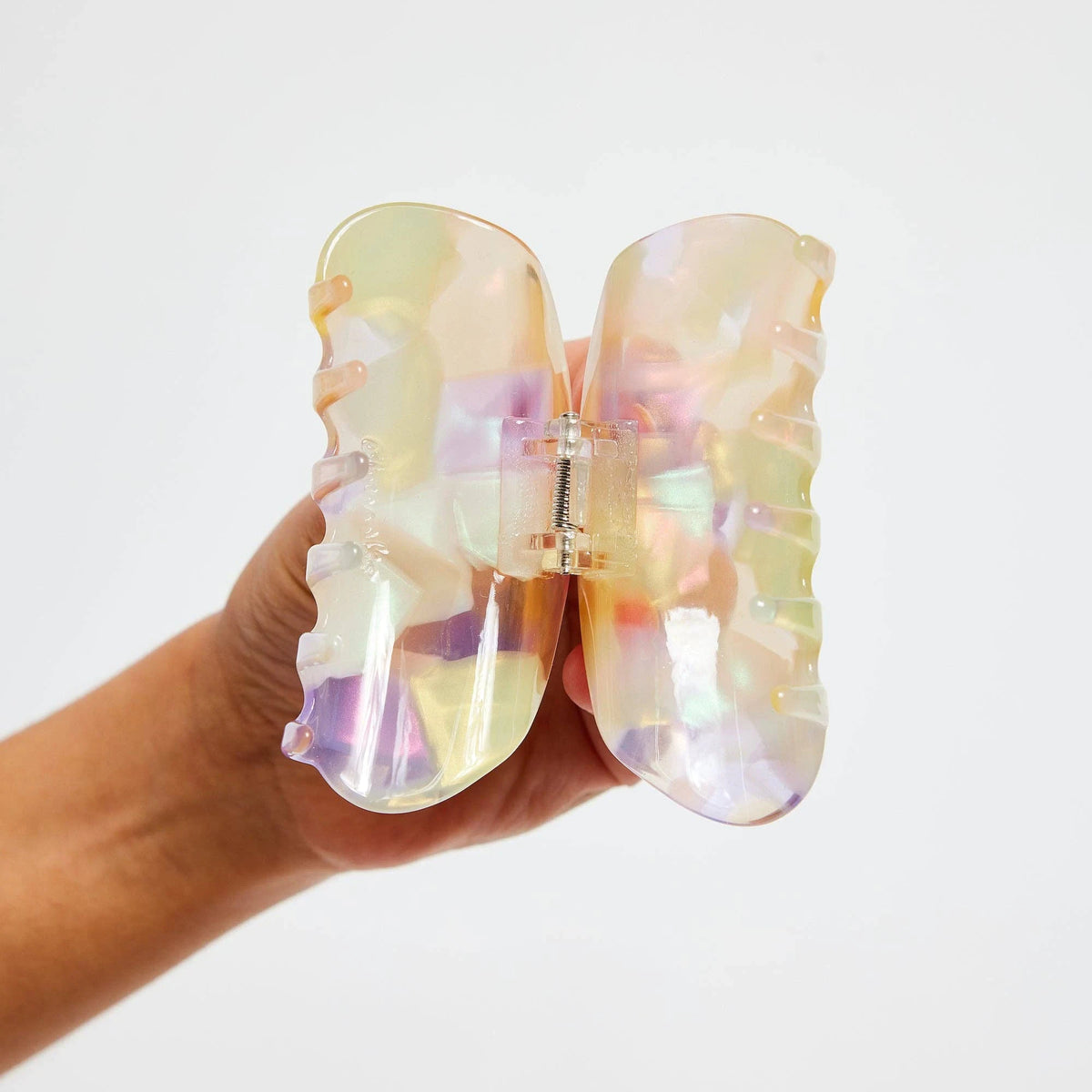 Pastel translucent acrylic claw clip shown open with central spring hinge