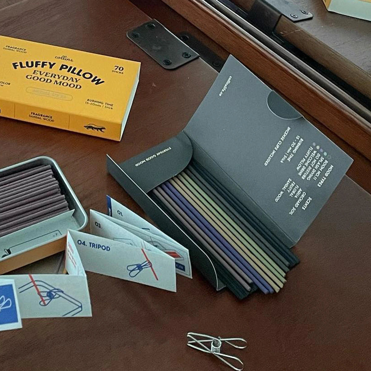 Incense stick boxes with bundled dark sticks and mood cards on a wooden surface