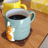 Light blue mug filled with coffee, showing cat illustration and 'Cat's Meow' quote
