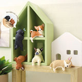 Resting Dogs Blind Box - Vol. 2 miniatures from Yell are displayed in a house-shaped green shelf, with some perched on the edges. Gather all five breeds to finish your adorable Doggy Desk Buddies collection.