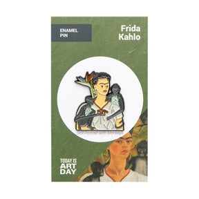 Enamel pin showing stylized Frida Kahlo with two monkeys on green and white backing card, gallery image 1