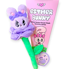 Purple Esther Bunny flower plush with large eyes and bows, attached to green stem, displayed with pink triangular packaging