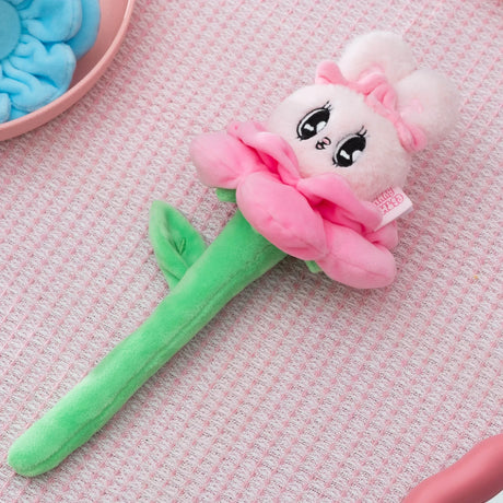 Pink Esther Bunny flower plush with green stem and bow on pastel textured fabric background