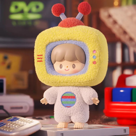 Plush keychain figure wearing a fuzzy yellow TV head costume with antennae and a white outfit standing on a vintage console