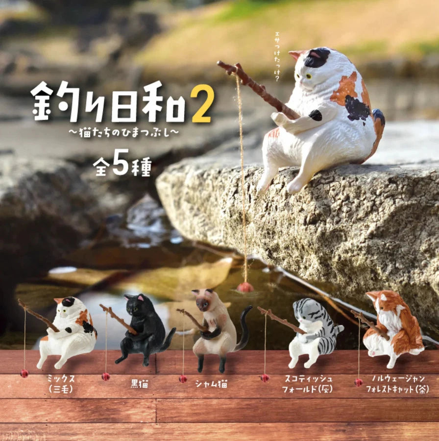 Five unique feline figures, each with their own design and color, form the enchanting Fishing Cats Blind Box - Vol 2 by Yell. With the text "Fishing Day 2," these cats are poised near water on a rocky surface, making an ideal gift for cat lovers.