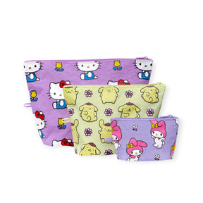 The Baggu Hello Kitty x Baggu Go Pouch Set includes four pastel purple and yellow zipper pouches featuring Hello Kitty, Pompompurin, and My Melody—perfect for fans of stylish and functional organizers.