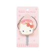 A Hello Kitty rubber key cover decorates your key, showcased on a pink card featuring charming flower and checkered patterns.