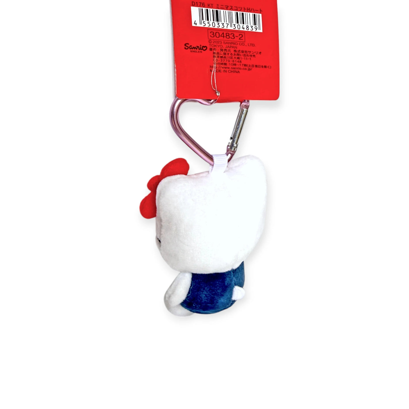 The Hello Kitty - Heart Clasp Keychain by Hello Kitty features a plush figure in a blue outfit with a red bow, and comes with an easy-to-attach heart clasp. Perfect for fans, this accessory stands out against its white background.