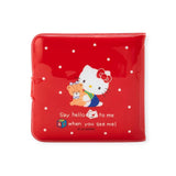 The Retro Hello Kitty Red Wallet by Hello Kitty showcases a vintage design with white polka dots and features Hello Kitty hugging a teddy bear while holding a cup, accompanied by the classic phrase: "Say hello to me when you see me!.