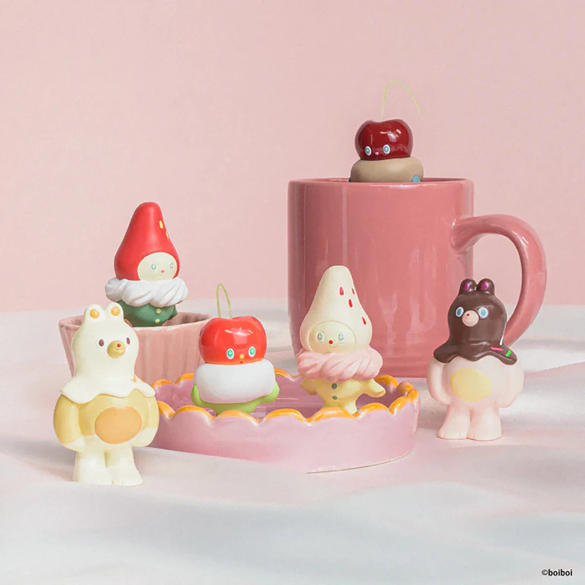 Assorted cute animal sweet figurines on a pink display stand