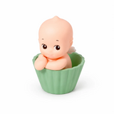 Kewpie baby figure in green ribbed cup, hands on chin