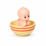 Kewpie baby figure in striped cup, yellow bowl with orange and red stripes