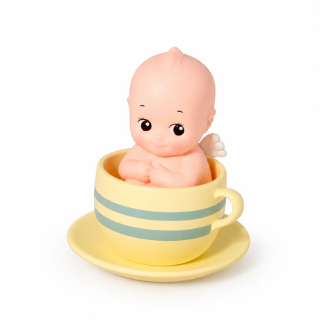 Kewpie baby figure in striped teacup, pale yellow cup and saucer
