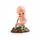 Kewpie blind box figure sitting with a shovel, wearing a yellow hat and white shorts
