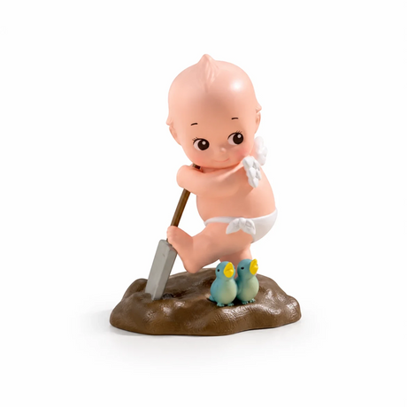 Kewpie blind box figure sitting with a shovel, wearing a yellow hat and white shorts