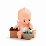 Kewpie blind box figure sitting in a brown box with small blue animal figurine
