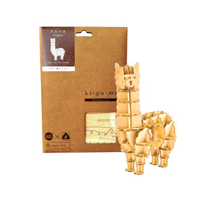 Ki-Gu-Mi wooden alpaca puzzle assembled next to eco-friendly packaging with product details visible