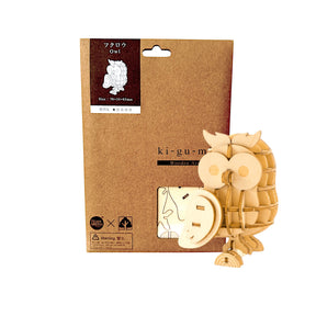 Ki-Gu-Mi Wooden Owl Puzzle partially assembled with visible cardboard packaging in brown kraft paper, gallery image one