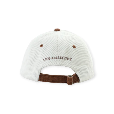 Back view of white corduroy cap with brown adjustable strap and embroidered "LIES COLLECTIVE" text above opening