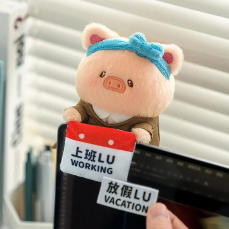 Plush piggy keychain in brown outfit with blue headband and “Working/ Vacation” tag.