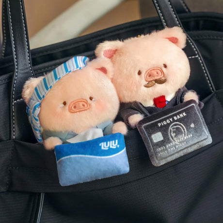 Pair of plush piggy office keychains in blue striped outfits with piggy bank tag.