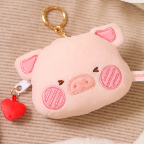 Soft pink pig-shaped pouch bag charm with embroidered snout and cheeks, featuring a red heart zipper pull and gold keyring clip