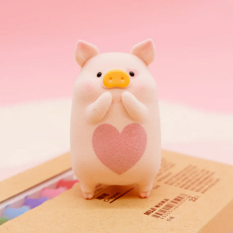 LuLu the Piggy Series 2 figure 4 with pink heart on soft textured body standing on brown box against pink backdrop