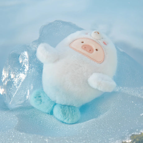 LuLu The Piggy - Baby Seal LuLu Plush Keychain features a round, white plush with a pig-like face and blue feet, resting on ice against a pale blue backdrop, perfect for ocean adventures.