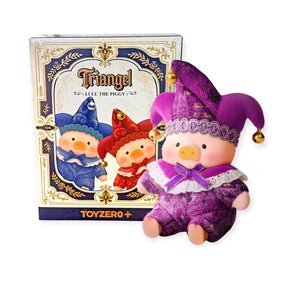 Purple plush pig doll dressed as a jester with gold bells sitting next to decorative box with pig faces on front