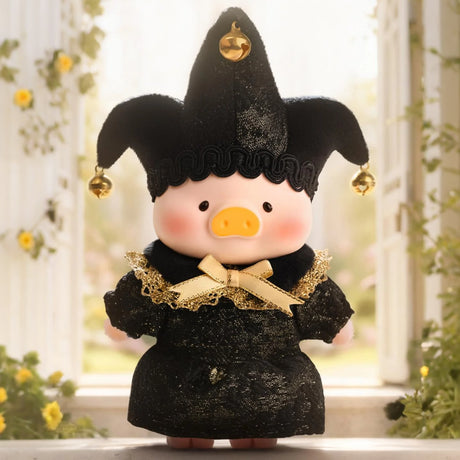 Small plush pig doll in black jester costume with gold bells and lace bow standing outdoors by flowers