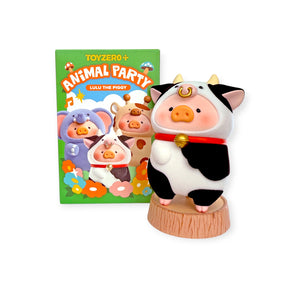 LuLu The Piggy figurine in cow costume standing on wooden stage with Animal Party blind box packaging behind, gallery 1