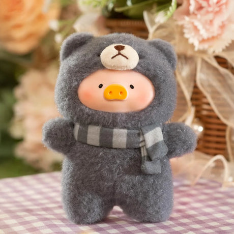 LuLu The Piggy’s Joyful Time Plush Pal Blind Box features her in a fuzzy gray bear costume and striped scarf, standing on a checkered surface with flowers for extra charm—a perfect surprise keychain plush from LuLu The Piggy.