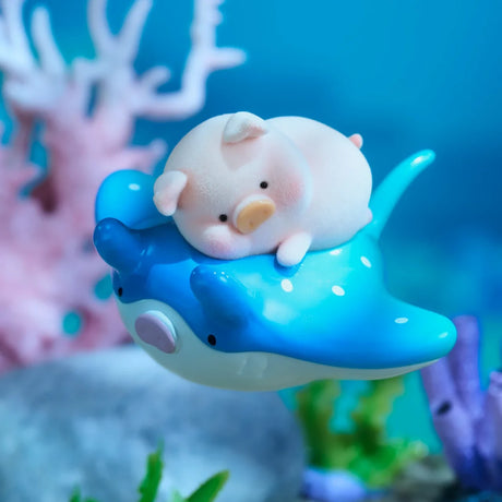 A LuLu The Piggy - Ocean Blind Box figurine from LuLu The Piggy shows a small pig on a blue manta ray, with coral and rocks in an underwater scene.