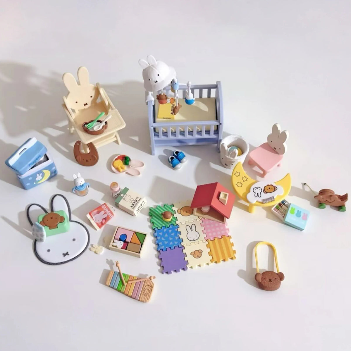 Mini baby room accessory assortment with crib, chairs, food, and puzzles